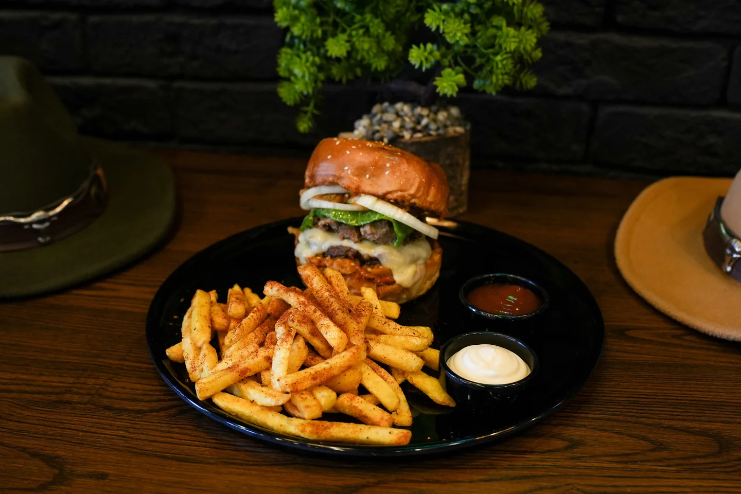 Representative stock photograph of a burger and fries on a dark wooden table